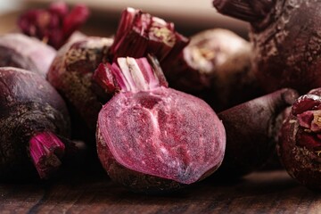 Several fresh beets are shown, some whole and some halved, revealing their rich magenta color. They...