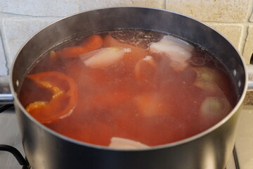Borscht is cooking in a pot on a gas stove