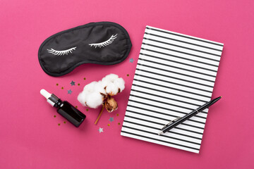 Sleeping mask with accessories on color background, top view. Sleeping routine concept