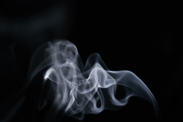 A graceful swirl of smooth white smoke against a dark background, forming a beautiful flowing shape