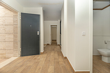 A modern hallway with recessed LED lighting and strategically placed mirrors to enhance the sense of space