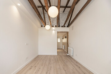 A bedroom steeped in history where centuries-old walnut beams create a natural canopy over the empty space, ready for decoration