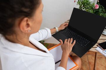 Woman Working Remotely on Laptop at Outdoor Workspace