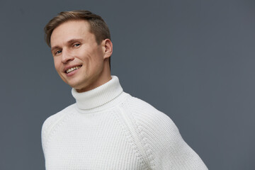 Smiling man wearing white turtleneck sweater look camera portrait isolated grey background concept...