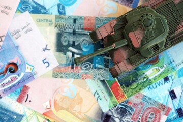 Kuwaiti dinar currency money bills and toy tank. The concept of army funds and weapons sales