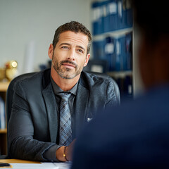 A view photograph of procurement worker being interviewed in office facing camera