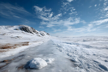 Icy Landscape with Single Snow Patch and Blue Sky