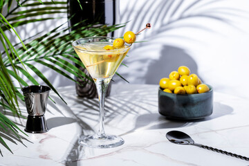 Dirty martini cocktail drink with gin or vodka, dry vermouth, olive brine and green olives with bar...