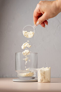 Protein powder. Pouring vanilla protein powder in a glass. Food supplement.