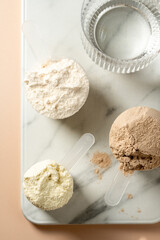 Protein powder in scoops. Different flavours of whey protein powders, top view