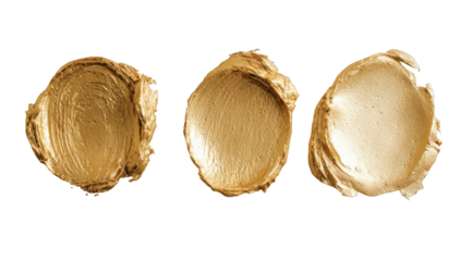 Three gold cosmetic smudges on black background