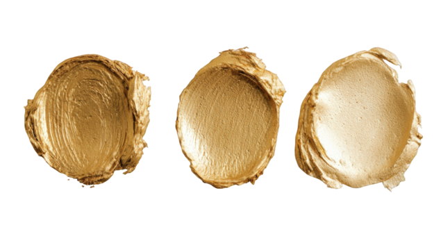 Three gold cosmetic smudges on black background