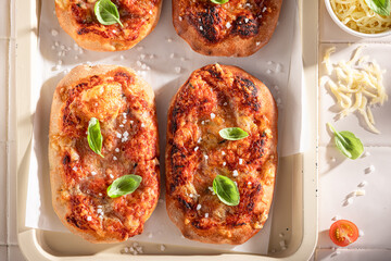 Delicious and homemade pinsa Margherita made of cheese and tomatoes.