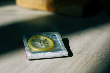 condom in a package in the interior of a living room in a residential building. concept: unwanted...