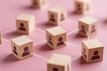 Wooden blocks with person icons connected by thin threads, forming a network on a pink background
