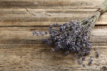 Bunch of aromatic lavender flowers on wooden table, closeup. Space for text