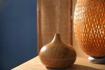 Modern aroma lamp on wooden table indoors
