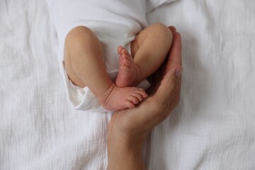 Father with his cute newborn baby on bed, top view