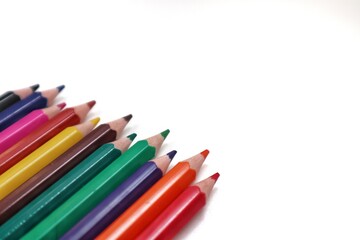 A dynamic composition of numerous colorful pencils scattered artfully across a clean white background, perfect for designs related to creativity, learning, or artistic endeavors.