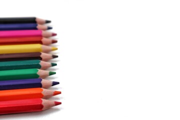 A close-up of a vibrant stack of colorful pencils, vertically oriented and positioned along the left side, showcasing their rich hues and texture. Ideal for artistic or educational backgrounds.