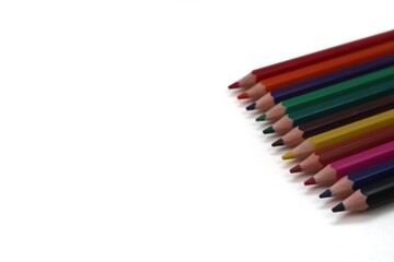 A close-up shot of a vibrant cluster of colorful pencils positioned on the right side of the frame, highlighting their textures and rich colors, with ample space on the left.