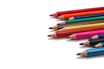 A colorful collection of sharpened pencils aligned neatly along the right edge of the frame,...