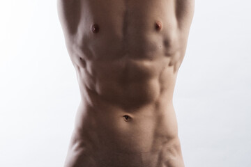 a dried male torso in close-up on a white isolated background. a male body after exhausting workouts and diets. clean skin and firm bodybuilder muscles