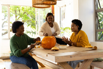 Halloween time, carving pumpkin, african american female friends at home together