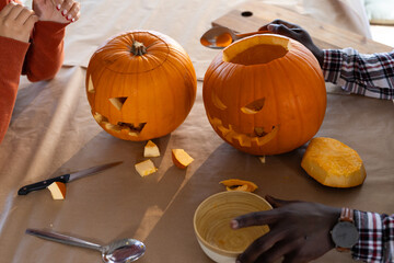 Halloween time, carving pumpkins together, multiracial couple at home