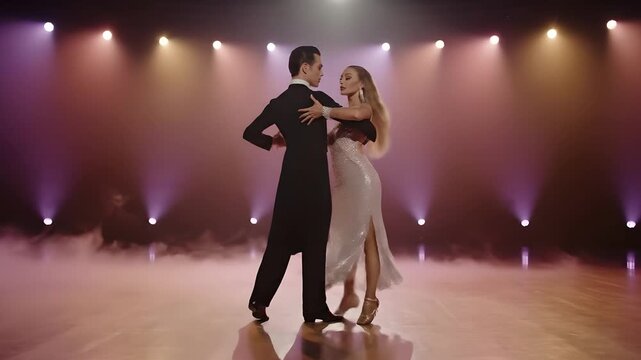 Elegant couple tango dancing. Ballroom dance performance, passionate tango steps on smoky stage. Wedding dance, formal occasion, or dance school demo.