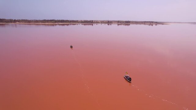 SENEGAL - 7.14.2025 - Stunning aerial view of boats traveling across Dakar, Senegal's Pink Lake.