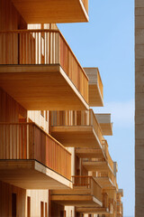 Fototapeta premium closeup view of modern wooden facades of buildings featuring contemporary wooden balconies and terraces