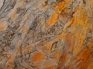 Close-up texture of oriented strand board (OSB) with natural wooden pattern and rough surface.