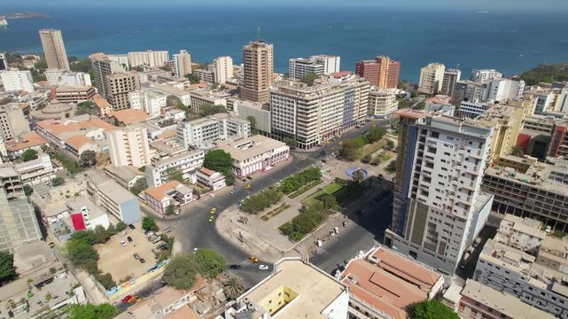 SENEGAL - 7.14.2025 - Excellent aerial footage starting to circle clockwise around cars driving through the coastal city of Dakar, Senegal.