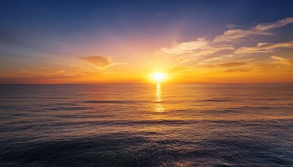 Obraz premium orange and yellow sunset over calm ocean water