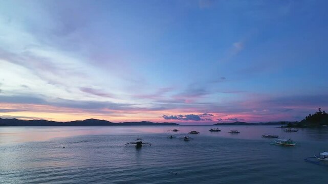 Vibrant evening sky with boats on the bay in Port Barton, Palawan, Philippines Colorful sunset sky over Port Barton bay in Palawan, Philippines