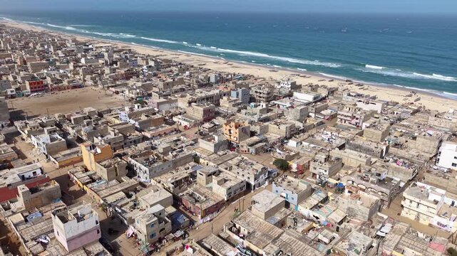 SENEGAL - 7.16.2025 - Stunning aerial footage circling counterclockwise towards the beach on Senegal's Island of Saint-Louis.