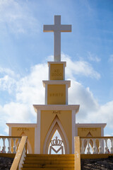 Yellow religious monument with cross