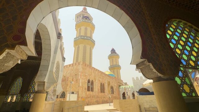 SENEGAL - 7.31.2025 - Great low angle view of a minaret through an arch of Senegal's Great Mosque Of Touba.