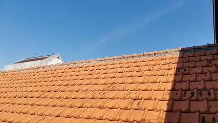 Clear blue sky above building rooftops, creating a bright and minimal urban landscape with architectural details and natural atmosphere in a sunny daylight scene