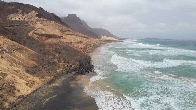 CAPE VERDE - 8.20.2025 - Stunning aerial footage moving up the coast of Sao Vicente, Cape Verde as waves lap the shore.