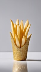 A creative shot of golden french fries in a golden container against a white background surface and backdrop