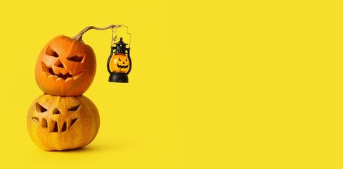 Halloween carved pumpkins and lantern on yellow background with space for text
