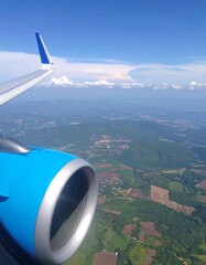 Airplane wing and engine over a landscape
