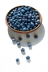 Blueberries in wooden bowl on a white