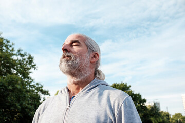 Senior man breathing fresh air in city park
