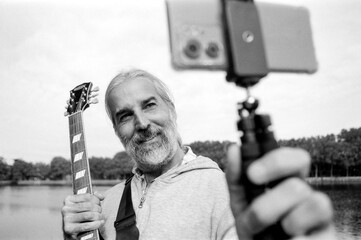 Musician streaming live music with electric guitar in black and white