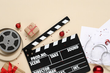 Composition with movie clapper, reels, storyboards and Christmas decorations on color background