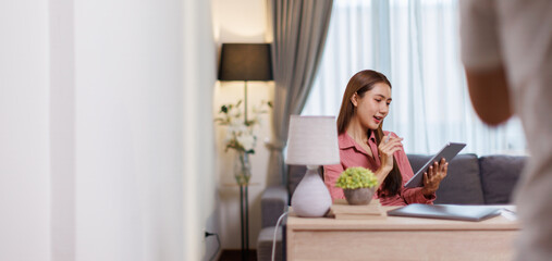 Thai asian young working professional female working on laptop at home wears smart formals
