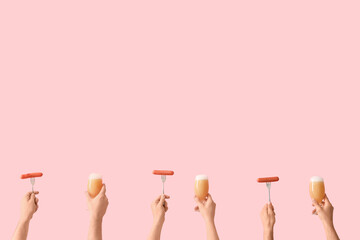 Many hands holding beer glasses and sausages on pink background
